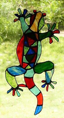 a stained glass window with a lizard on it's back and legs, in front of some trees