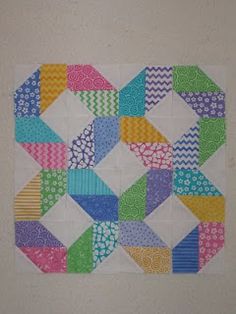 a multicolored quilt hanging on the wall