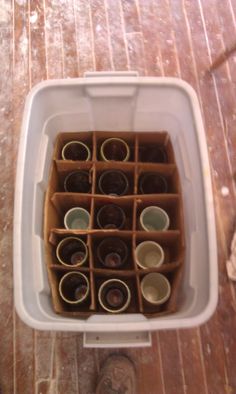 a white container filled with cups on top of a tiled floor