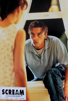 a young man sitting on top of a toilet next to a woman in a white dress