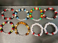 several bracelets with different colors and designs on them sitting on a table next to each other