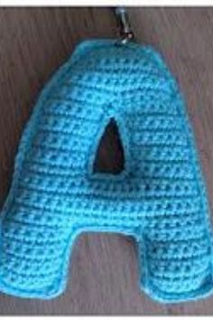 a crocheted blue letter hanging from a hook