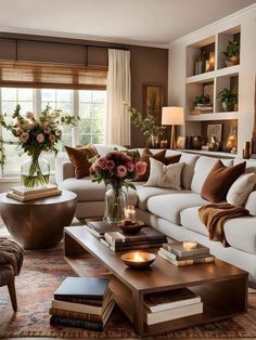 a living room filled with lots of furniture and flowers in a vase on top of a coffee table