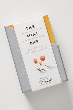 the mini bar is sitting on top of a white table with two glasses in it