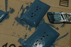 some blue paint is sitting on top of a cardboard box and it's been painted