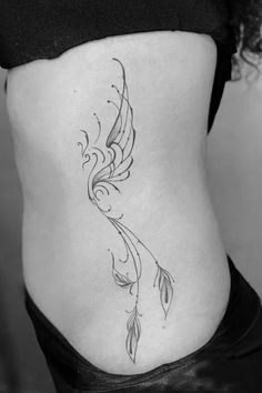 a woman's stomach with a bird tattoo on the side and an arrow in the middle