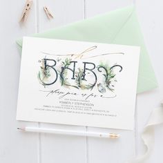 a card with the word baby written on it next to a pen and paper clips