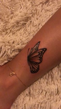 a woman's arm with a butterfly tattoo on the left side of her leg