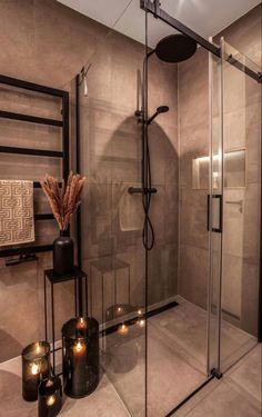 a glass shower with candles on the floor