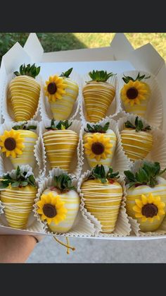 chocolate covered strawberries with sunflowers on them in a white paper box, ready to be eaten