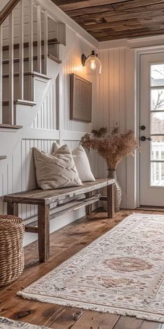 a wooden bench sitting in front of a door next to a white rug on top of a hard wood floor