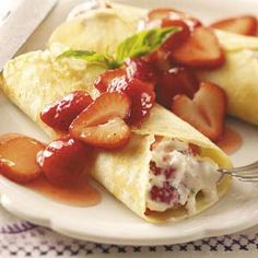 two crepes with strawberries and whipped cream