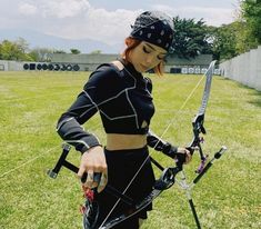 a woman in black outfit holding a bow and arrow