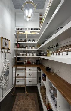 a narrow kitchen with white cabinets and shelves