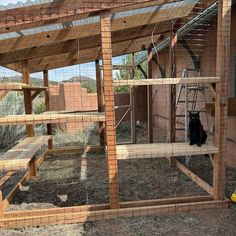 a black cat sitting on top of a chicken coop