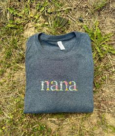 Made to order floral nana embroidered shirts! Can be made on a short or long sleeved t shirt or a long sleeve crewneck sweatshirt! Shirts are UNISEX sizing Shirts are JERZEEs/ GILDAN/ Fruit of the Loom brand **Machine wash COLD and hang dry to extend embroidery life** Sweatshirts are made to order so processing time is 3-7 business days. Please message me if you need your order sooner, and I will do everything I can to get it to you ASAP! Message me for any custom orders! Mother's Day Gift Tops With Letter Embroidery, Embroidered Tops For Mother's Day Gift, Casual T-shirt With Floral Embroidery For Gift, Custom Embroidery Spring Tops As Gift, Custom Embroidered Tops As Spring Gift, Casual Letter Embroidery T-shirt As Gift, Spring Custom Embroidered Top As Gift, Casual T-shirt With Letter Embroidery As Gift, Custom Embroidered Top For Gift In Spring