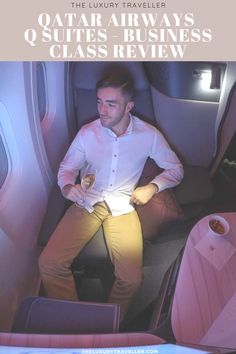 a man sitting in an airplane seat holding a drink