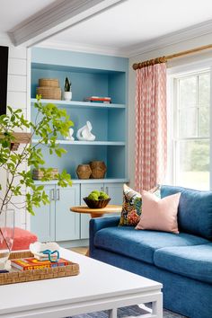 a living room with blue couches and white coffee table in front of a window