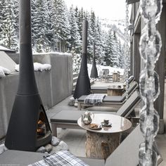 outdoor seating area with fireplace and snow covered trees