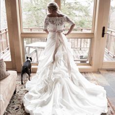 a woman standing in front of a window next to a dog