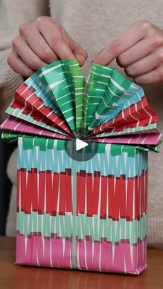 a person opening up a colorful gift box