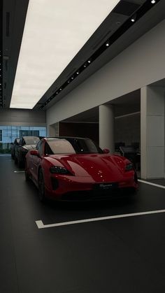 two red sports cars parked in a garage