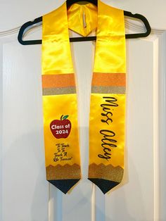 an orange and yellow graduation stole hanging on a door