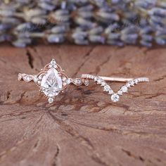 two wedding rings on top of a piece of wood with lavender flowers in the background