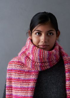 a woman wearing a multicolored knitted scarf