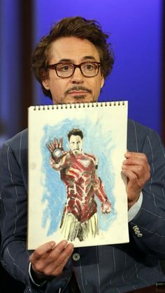 a man holding up a drawing of iron man