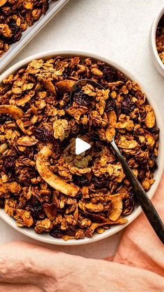 a bowl filled with granola next to another bowl full of granola