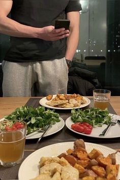 a man standing in front of plates of food