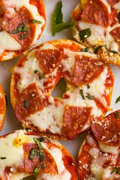 mini pizzas with pepperoni, cheese and basil sprinkled on the top