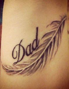 a tattoo with the word dad written in cursive writing and a feather on it