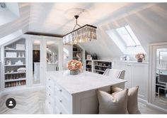 a white kitchen with an island and chandelier