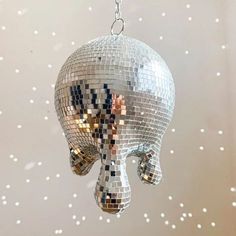 a disco ball shaped like an elephant hanging from a chain