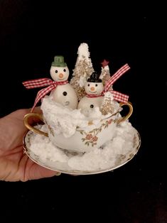 a teacup with snowmen in it is sitting on a saucer