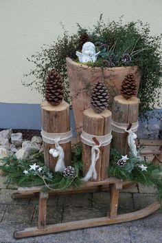 a wooden sleigh decorated with pine cones and greenery