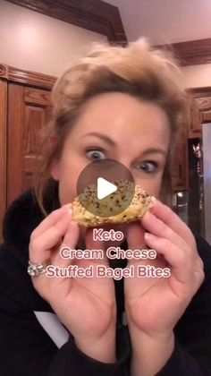 a woman holding up a cookie in front of her face with the words keto cream cheese stuffed bagel bites