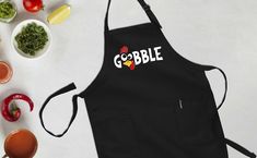 an apron with the word gobble on it next to bowls of vegetables and sauces