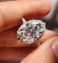 a person holding a diamond ring in their hand