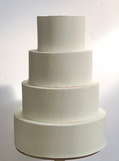 a three tiered white cake sitting on top of a table