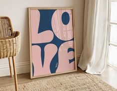 a framed art print sitting on top of a rug next to a wicker chair