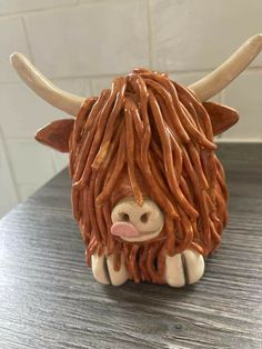 a ceramic animal with long hair sitting on a table