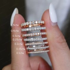 a woman's hand holding three rings with different sizes and shapes on them,