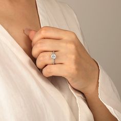 a woman wearing a diamond ring on her finger