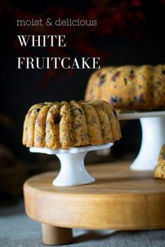 two cakes sitting on top of a cake stand with the words, most & delicious white fruitcake