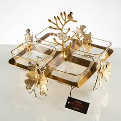 two trays with gold leaf decorations on them and a tag hanging from the side