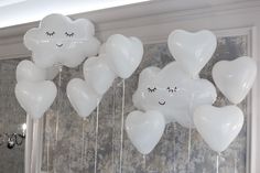 white balloons with faces drawn on them hanging from the ceiling