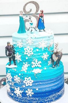 a frozen princess birthday cake with blue frosting and white snowflakes on top